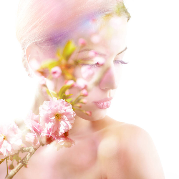 Beautiful young female face with spring blooming cherry tree flowers, double exposure. Beauty treatment, youth, springtime concept - Fotoğraf, Görsel