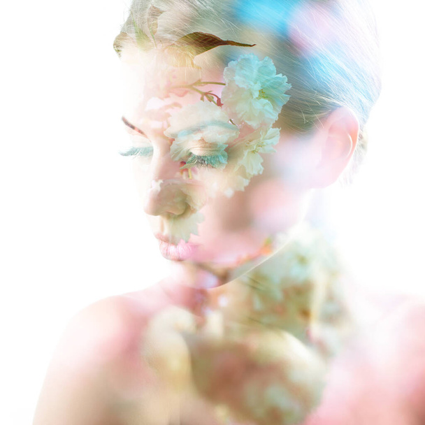 Beautiful young female face with spring blooming cherry tree flowers, double exposure. Beauty treatment, youth, springtime concept - Valokuva, kuva