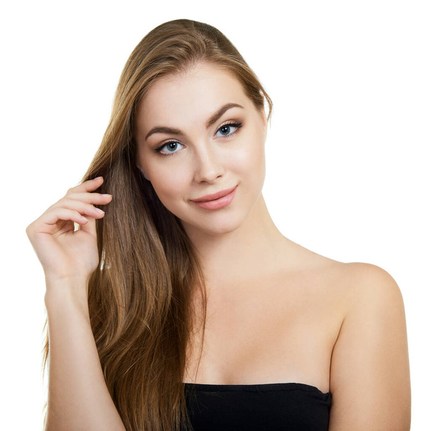 Giovane donna attraente con un trucco perfetto e lunghi capelli biondi in posa e sorridente in studio su sfondo bianco, ritratto femminile di bellezza.  - Foto, immagini