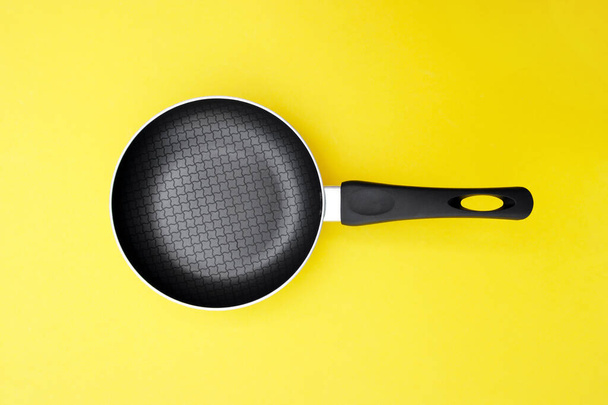 A non-stick skillet on a bright yellow background. Cooking concept. - 写真・画像