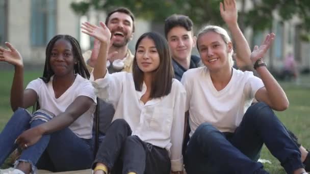 Estudiantes felices saludando mientras posan al aire libre - Metraje, vídeo