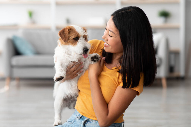 Primer plano de atractivo asiático mujer abrazo con su perrito - Foto, Imagen