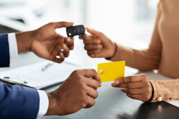 Comprando Auto. Mujer dando tarjeta de crédito al vendedor y tomando llaves del coche - Foto, Imagen