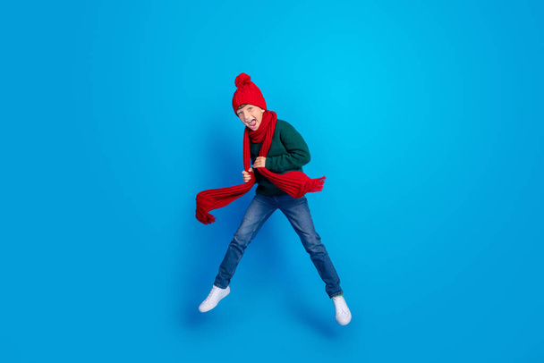 Full length body size photo boy jumping up wearing winter clothes isolated bright blue color background - Foto, Bild