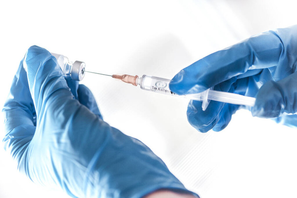 Een arts bereidt een vaccin voor de witte achtergrond, close-up - Foto, afbeelding