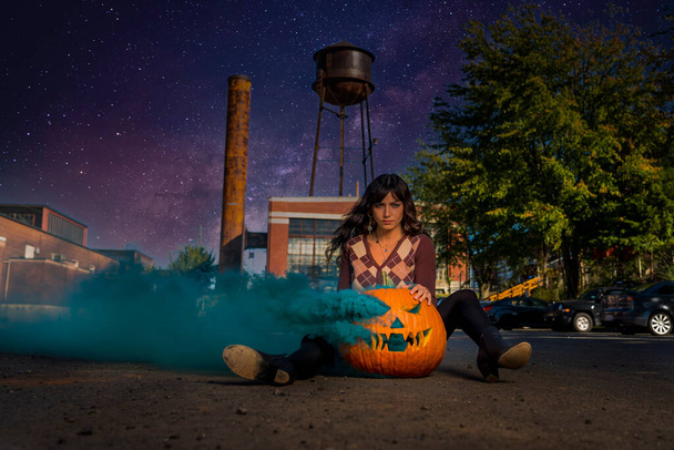Una hermosa modelo posa con una calabaza para la temporada de Halloween en los Estados Unidos - Foto, imagen