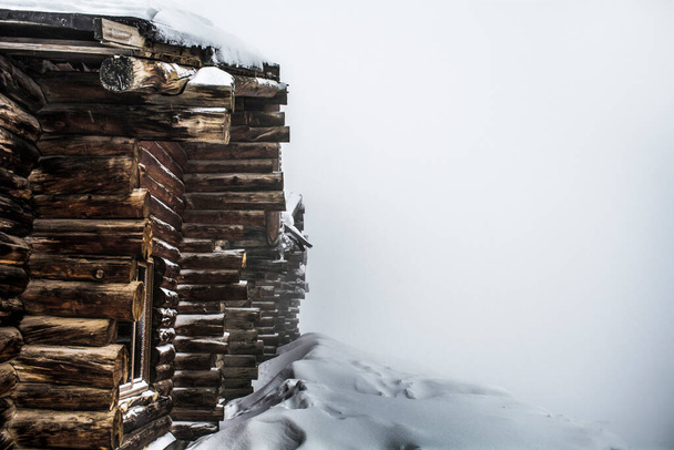 puinen mökki lähes lumen peitossa talvella tilaa tekstiä - Valokuva, kuva