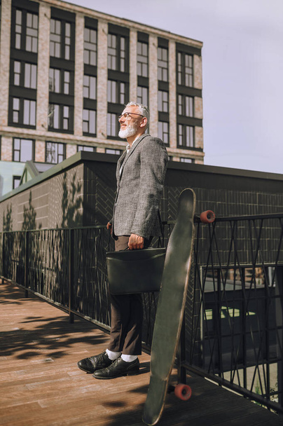 Elegant gray-haired matured man standing on a urban background - Foto, Imagem