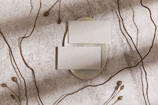 Stylish minimalistic flat lay composition with mock up visit cards, rock, natural materials, dry plants and personal accessories. Neutral colors, top view, template. - Photo, Image