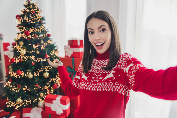 Photo of young excited girl make video vlogger social network demonstrate hand xmas tree lights magic indoors - Photo, image