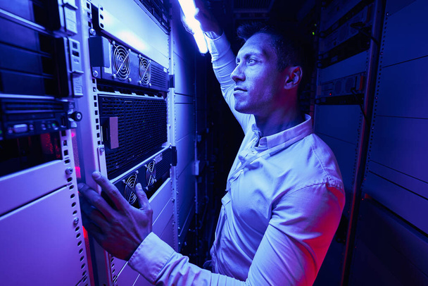 Experienced serious system administrator monitoring network server - Photo, Image