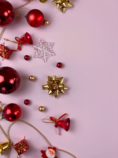 Karácsonyi dekorációk, ajándék doboz szalagok, arany golyók, hópelyhek, piros golyó rózsaszín háttér - Fotó, kép