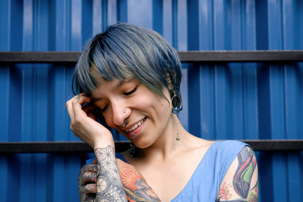 Beautiful young woman with short blue hair on a blue background lifestyle portrait. - Valokuva, kuva