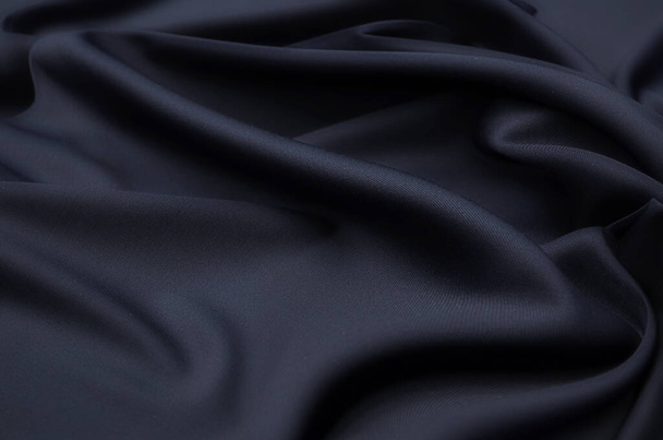 Close-up tekstury naturalnego szarego lub czarnego materiału lub tkaniny w tym samym kolorze. Tekstura tkaniny z naturalnej bawełny, jedwabiu lub wełny lub lnu materiału włókienniczego. Czarne tło płótna. - Zdjęcie, obraz