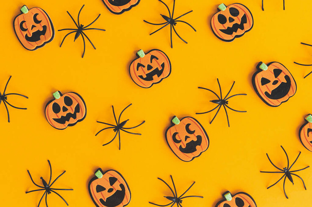 Fijne Halloween. Pompoenen jack o lantaarn en spinnen plat lag op oranje achtergrond. Halloween decoraties lay-out op oranje papier. Halloween achtergrond. Feestelijk patroon - Foto, afbeelding