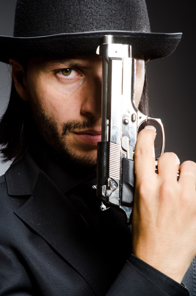 Man wearing vintage hat with gun - Foto, Bild