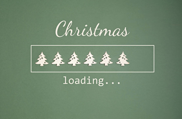 Strona internetowa ładowanie bar z drewnianymi choinkami i tekst Boże Narodzenie ładowania na zielonym tle. Koncepcja sezonu zimowego - Zdjęcie, obraz