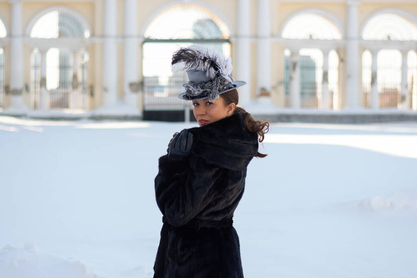 una donna vestita come una nobildonna del XIX secolo si trova vicino a un vecchio maniero house.russian inverno - Foto, immagini
