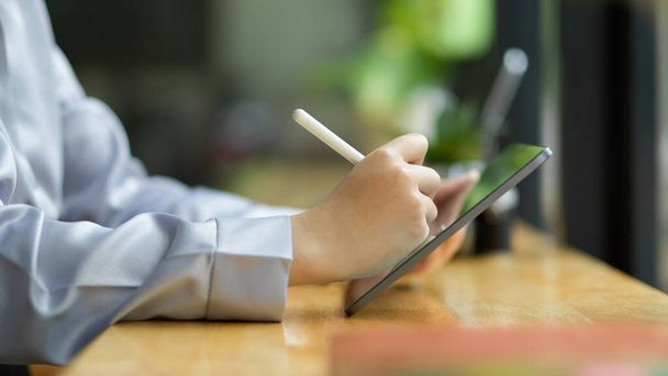 Nahaufnahme, Seitenansicht der Geschäftsfrau, Unternehmerin mit Tablet und Stift an ihrem Arbeitsplatz. - Foto, Bild