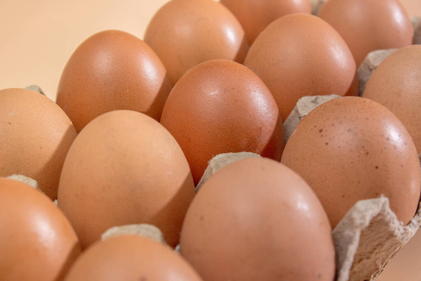 Tray of brown eggs over yellow background - Photo, Image
