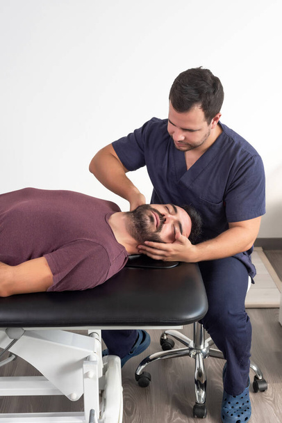 Physiotherapist performing a neck massage on a patient - Fotoğraf, Görsel