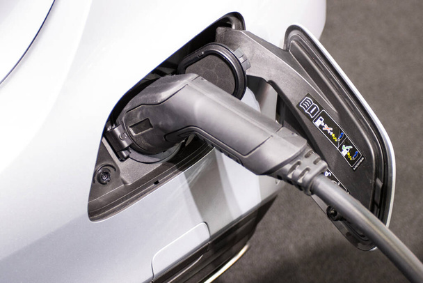 o carregamento da bateria para o carro novas inovações automotivas a fonte de alimentação conectada a um carro elétrico que está sendo carregado, conceito de inovação energética. - Foto, Imagem