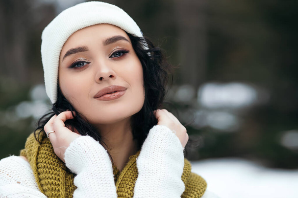 Mujer bonita sonrisa pie fuera de la calle nieve viejo parque bosque tiempo invierno vacaciones Año Nuevo Navidad vestido de punto cálido suéter y bufanda, ojos azules copiar espacio borroso fondo bokeh. - Foto, Imagen