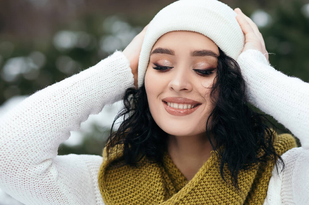 Güzel kadın gülümsüyor sokak karları eski orman hava durumu kış tatili yeni yıl Noel 'i örgü, kalın kazak ve eşarp, mavi gözler fotokopi alanı bulanık arka plan. - Fotoğraf, Görsel