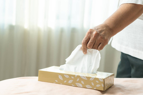 Idős nők kézi szedés szalvéta / szövet papír a zsebkendő doboz - Fotó, kép