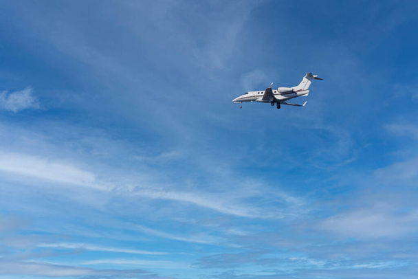 ιδιωτικό τζετ κατά την προσγείωση σε μπλε φόντο ουρανό - Φωτογραφία, εικόνα