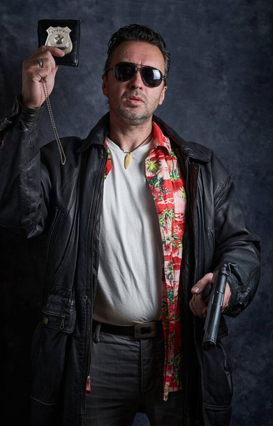 Undercover cop on a dark background, a policeman at work, tough detective, fake badge - Photo, Image