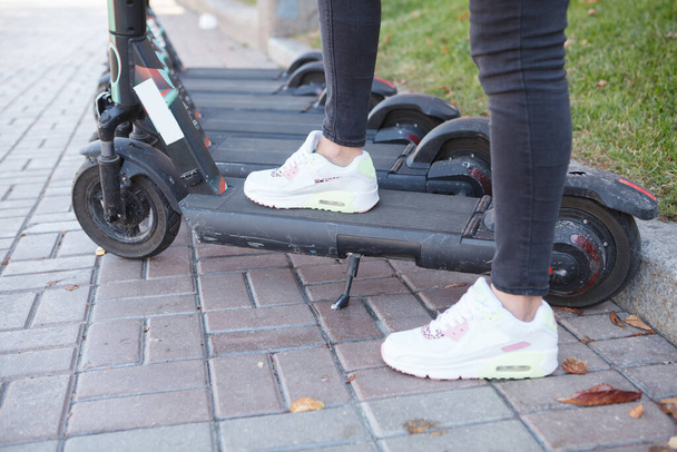 Cropped shot of unrecognizable woman stepping on electric scooter - Foto, immagini
