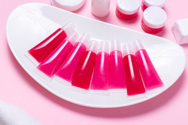 Lot of homemade lip glosses on pink background - Foto, Bild