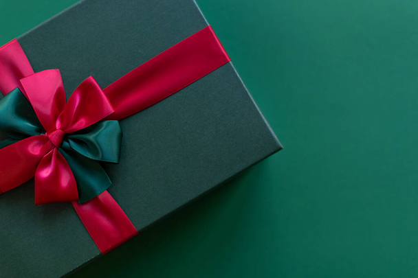 Подарочная коробка для рождественских праздников на зеленом фоне. Место для текста - Фото, изображение