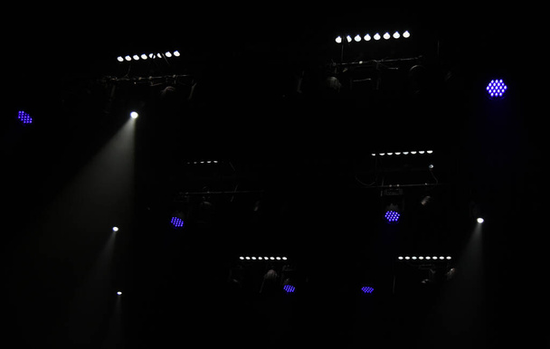 Bühnenbeleuchtung von Scheinwerfern auf schwarzem Hintergrund. - Foto, Bild