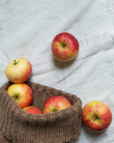 ripe fragrant apples scattered from a bag on a white background. autumn composition about apples. place for text. - Фото, зображення