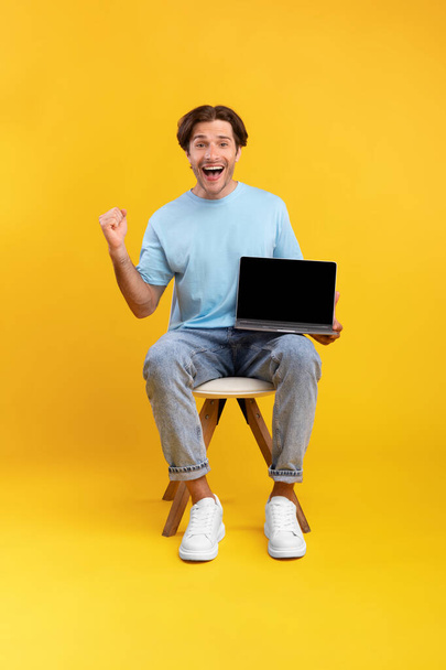 Aufgeregter Mann zeigt schwarzen leeren Laptop-Bildschirm schreit ja - Foto, Bild