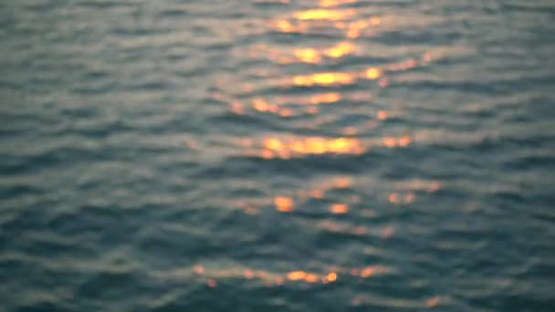 Geschlungenes Video von wunderschöner Wasseroberfläche und Sonnenlicht über dem Horizont. Verschwommen. - Filmmaterial, Video