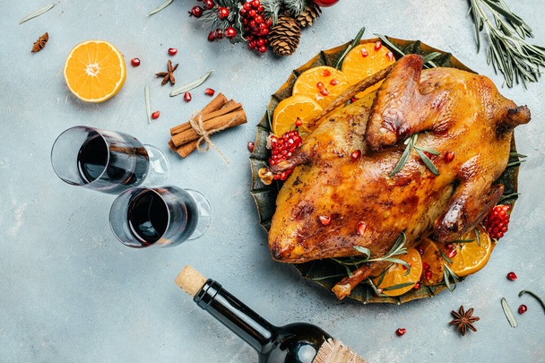 Vánoční pečené kachní pomeranče, rozmarýn, bobule a červené víno podávané na vánočním slavnostním stole. pohled shora. - Fotografie, Obrázek