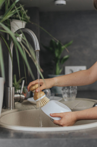 Крупним планом дитячі руки миття посуду з екологічним пензлем посуду
. - Фото, зображення