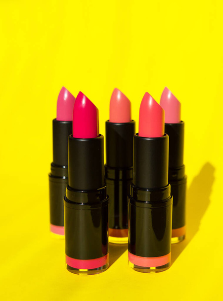 bright juicy lipstick of pink shades. makeup for girls. bright lipstick close-up on a yellow background. photography as a background for a makeup artist. article for a blogger, fashionable cosmetics. temsto for text. - Φωτογραφία, εικόνα