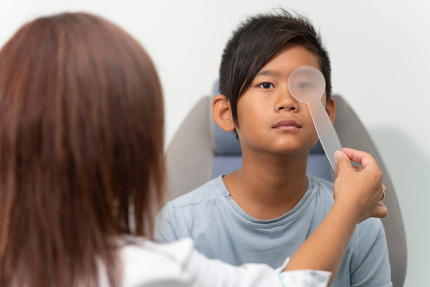 Aasialainen poika konsultointi silmälääkäri nainen - Valokuva, kuva