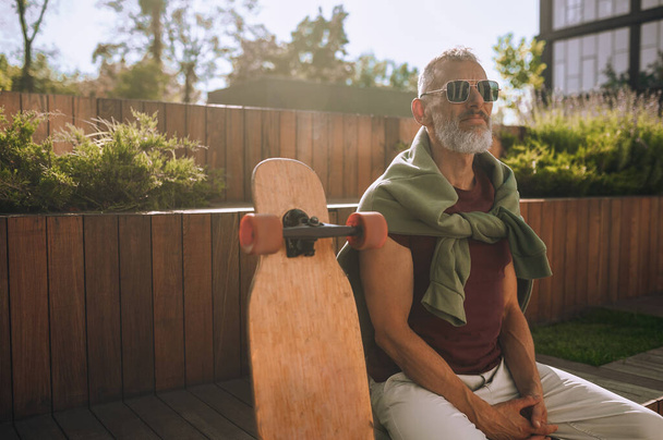 Tyylikäs harmaa-tukkainen urheilullinen mies rentouttava ulkoilun jälkeen - Valokuva, kuva