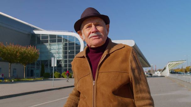 Ritratto di anziano pensionato nonno turistico soggiorno vicino alla hall dell'aeroporto in attesa di aereo, viaggio - Foto, immagini