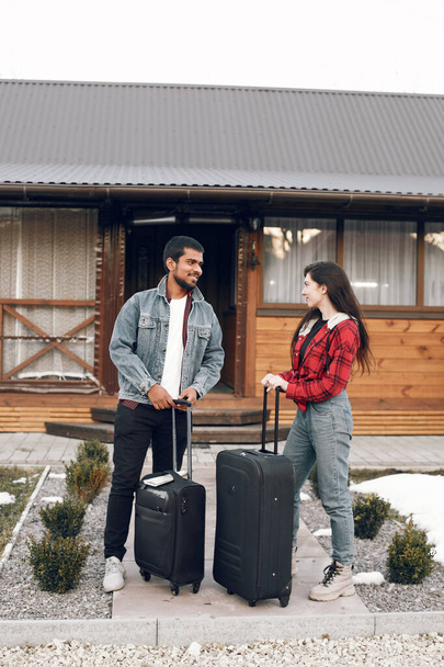 Group frinends with suitcases standing at wooden building - Photo, image