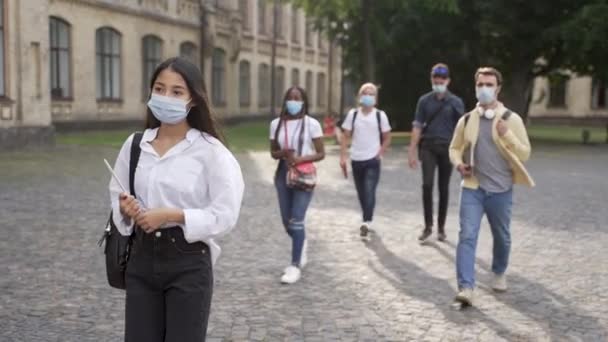 Wielorasowi studenci w maskach do chodzenia na zajęcia - Materiał filmowy, wideo