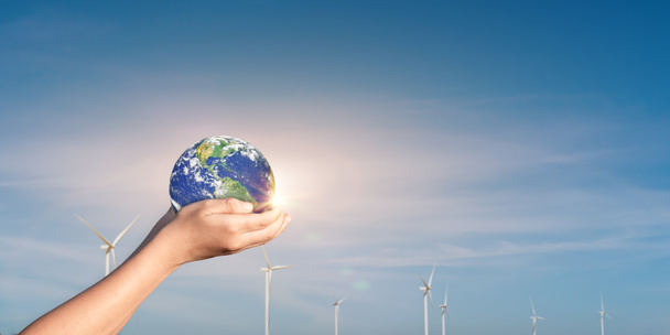 Hands holding Globe, Earth on wind turbine field background. Concept of world environmental protection and renewable energy. Elements of this image furnished by NASA - Foto, Bild