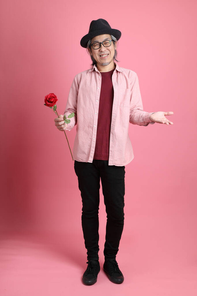 The senior Asian man standing on the pink background. - Foto, imagen