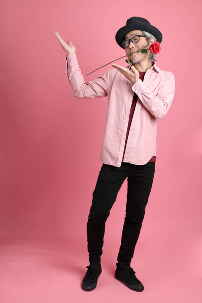 The senior Asian man standing on the pink background. - Foto, Imagem