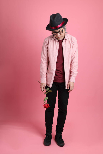 The senior Asian man standing on the pink background. - Foto, imagen